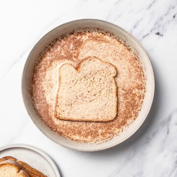Dipping bread in batter for French toast.