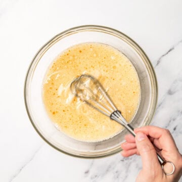 Whisking wet ingredients in glass bowl.