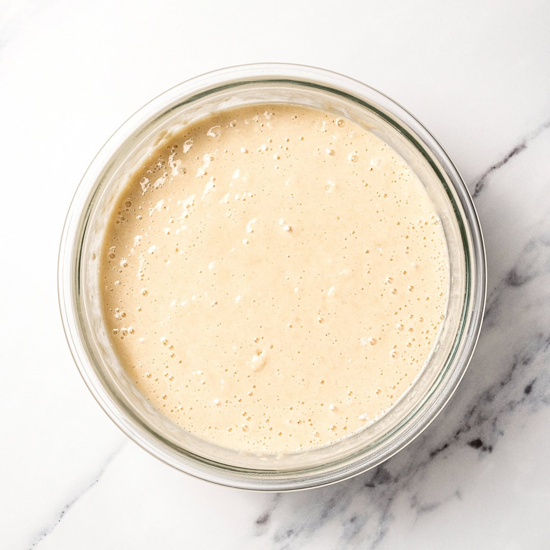 This soft and fluffy vegan vanilla cake recipe is perfect for birthdays and celebrations! It's super easy to make with pantry ingredients. Vegan vanilla cake batter in bowl.
