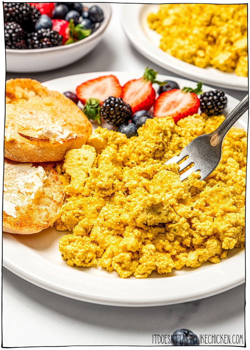 Fork digging into tofu scramble on plate.