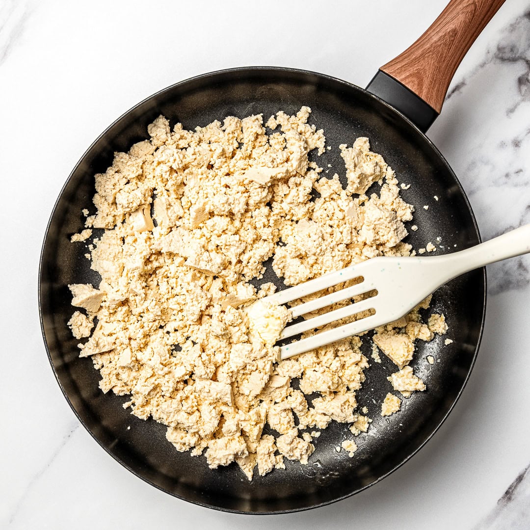 Tofu crumbles cooking in skillet.