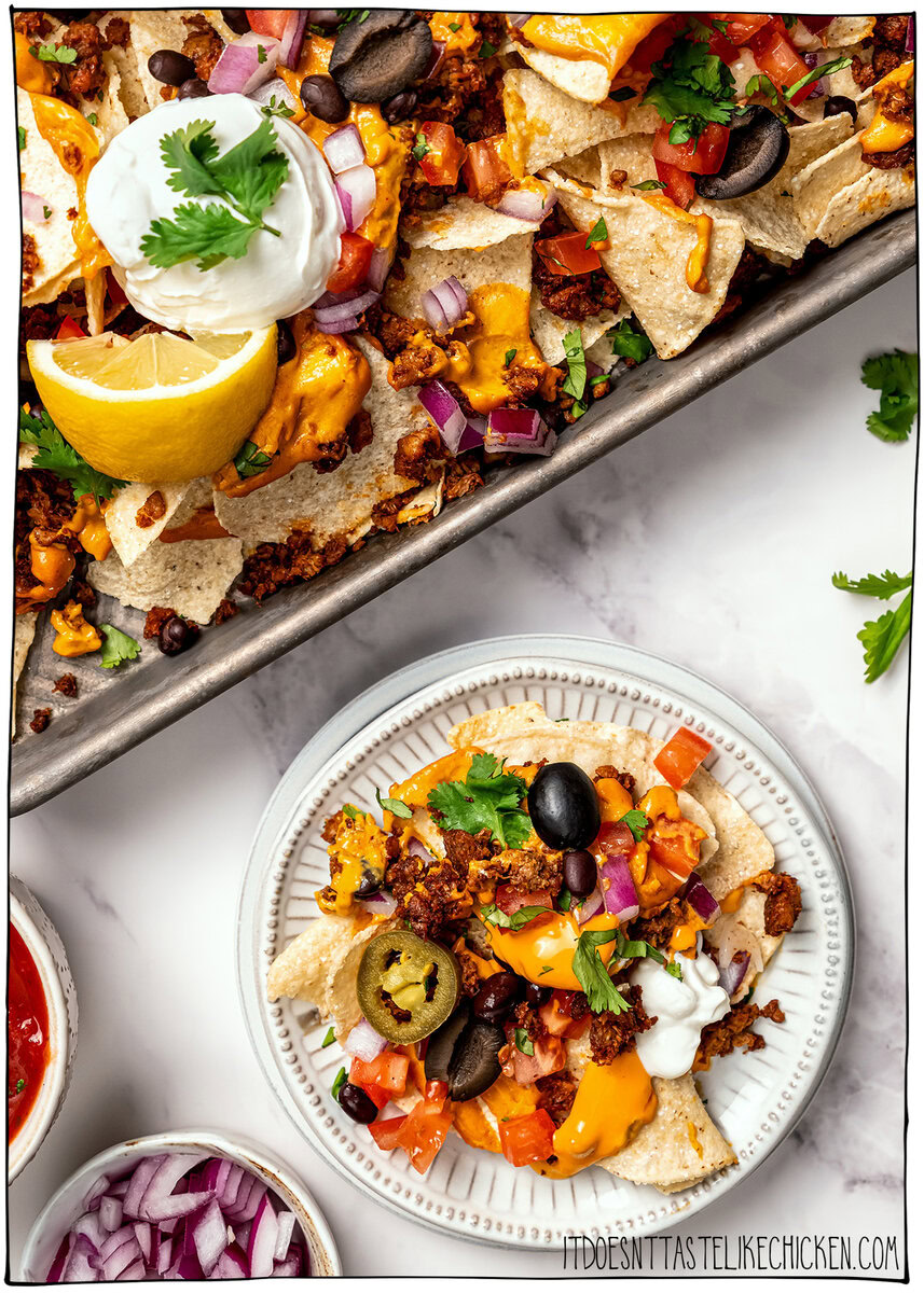 Plate of vegan nachos set next to sheet pan.