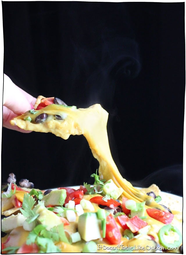 The best damn loaded vegan nachos from here to Timbuktu! Homemade vegan nacho cheese only takes 15 minutes to make, then just load up the tortilla chips will all the best toppings! So easy. #itdoesnttastelikechicken