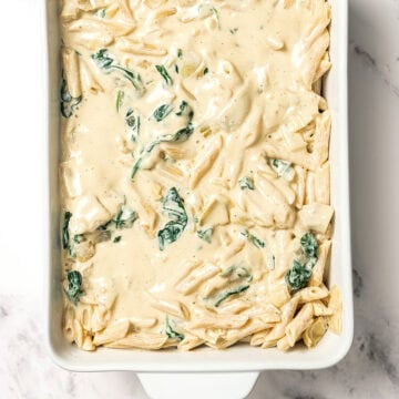 Casserole dish with creamy spinach artichoke pasta.