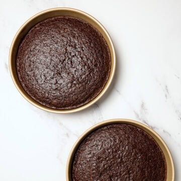 Two vegan chocolate cake layers in round pans.
