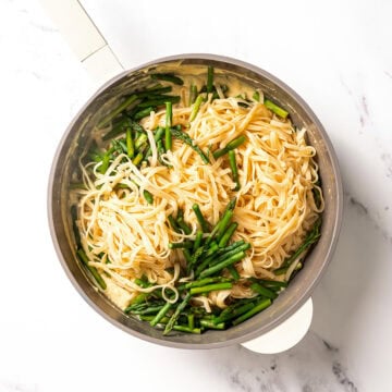 Cooked pasta and asparagus added to cream sauce.