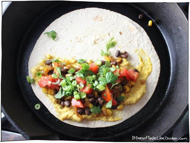 Vegan Black Bean & Corn Quesadilla! Spiced black beans and corn, on top of a homemade melty dairy-free cheese, with diced tomato, green onions, and cilantro. This is the perfect easy weeknight meal, and bonus, most of it can be made ahead of time, making it quick to grab and assemble when hunger strikes. #itdoesnttastelikechicken