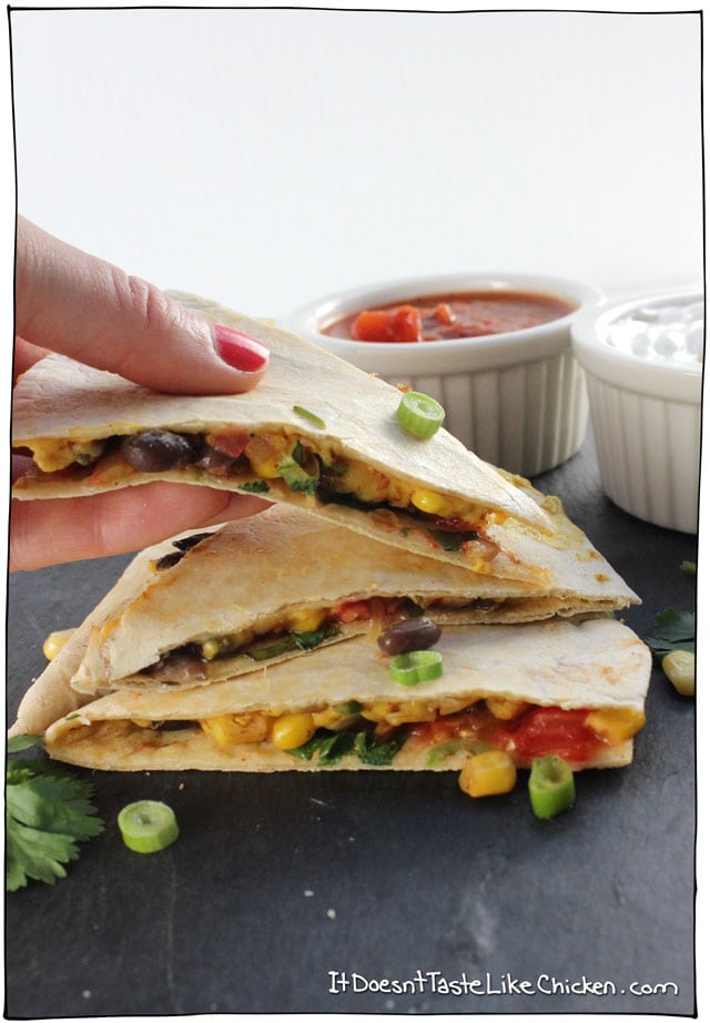 Vegan Black Bean & Corn Quesadilla! Spiced black beans and corn, on top of a homemade melty dairy-free cheese, with diced tomato, green onions, and cilantro. This is the perfect easy weeknight meal, and bonus, most of it can be made ahead of time, making it quick to grab and assemble when hunger strikes. #itdoesnttastelikechicken