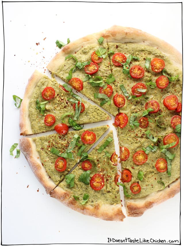 Vegan Creamy Pesto Pizza! It takes just 5 minutes to whip up this creamy, rich, basil bursting, zesty, garlic, peppery sauce. Top with tomatoes and bake. Yum! Dairy-free. #itdoesnttastelikechicken