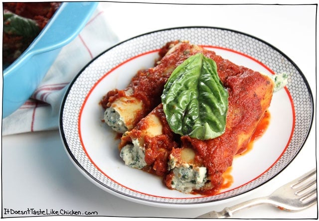 Fresh spinach and basil mixed with easy to whip up dairy-free ricotta, stuffed into cannelloni pasta, and coated in tomato sauce. Vegan Spinach & Ricotta Cannelloni is so delicious no one will even know it's vegan! #itdoesnttastelikechicken