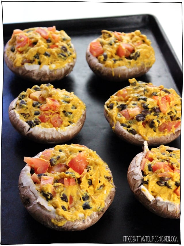 Vegan Nacho Stuffed Portobellos! Portobello mushrooms are stuffed with a homemade vegan nacho cheese filled with black beans and tomato. Bake or grill the mushrooms then top with guacamole for a fiesta in your mouth! Makes a great main when paired with Mexican rice and corn on the cob. #itdoesnttastelikechicken #veganrecipes #veganmains