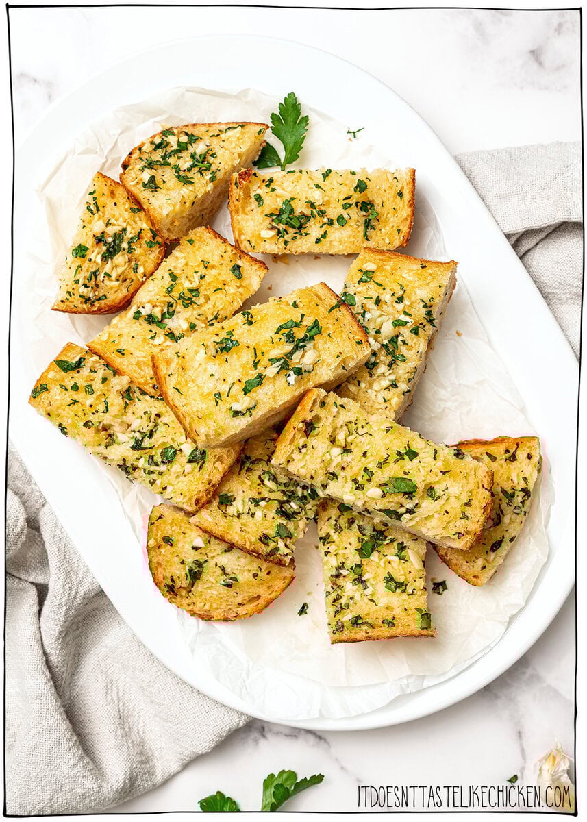 Pieces of vegan garlic bread on platter.