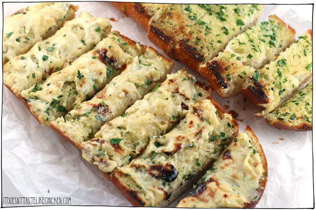Cheesy Vegan Garlic Bread! This dairy-free garlic bread is quick and easy to make. Smothered in a homemade vegan cheese, perfect paired with your favourite Italian pasta dish. There's also an option for classic garlic bread (without cheese). #itdoesnttastelikechicken #veganrecipes #dairyfree