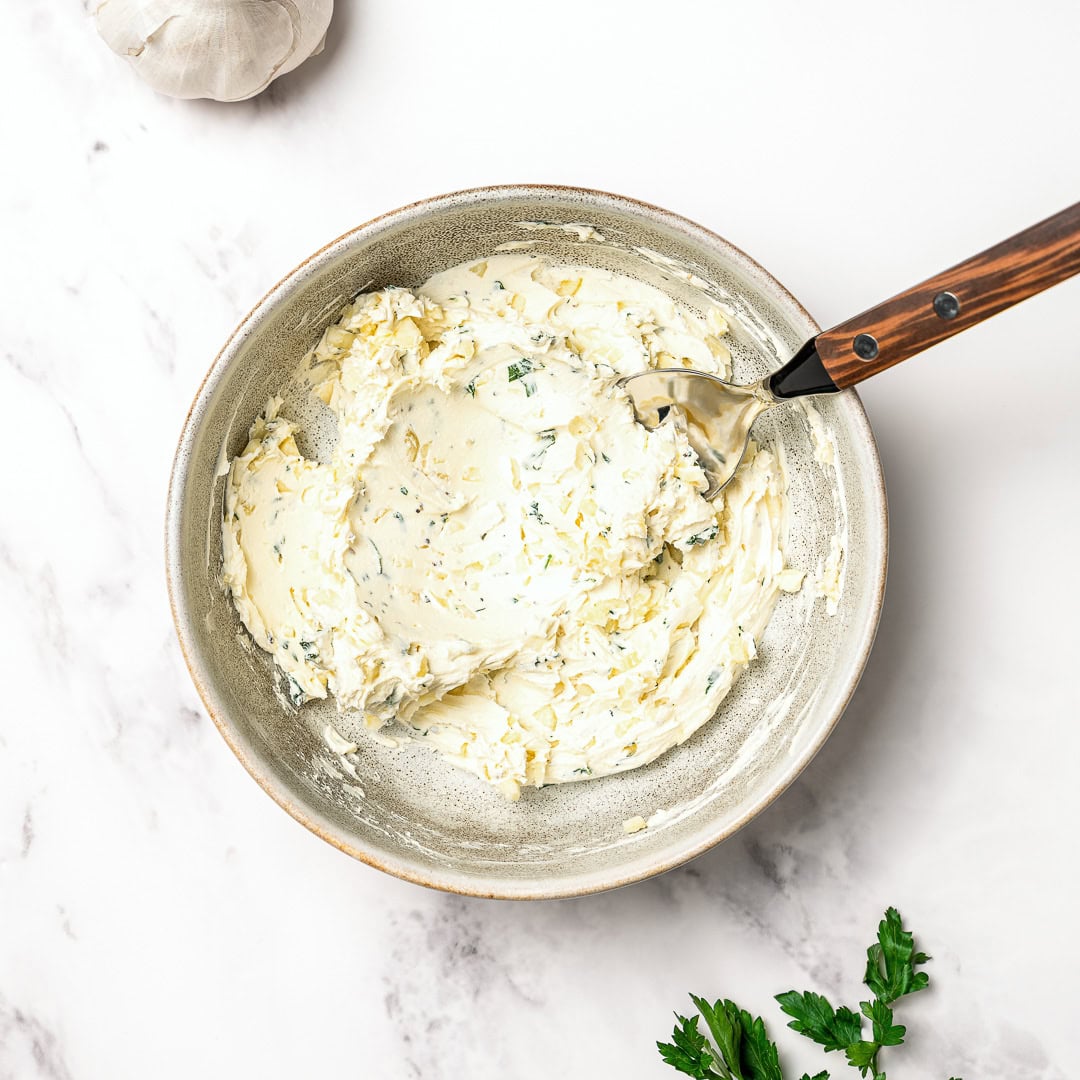 Garlic butter in bowl with spoon.