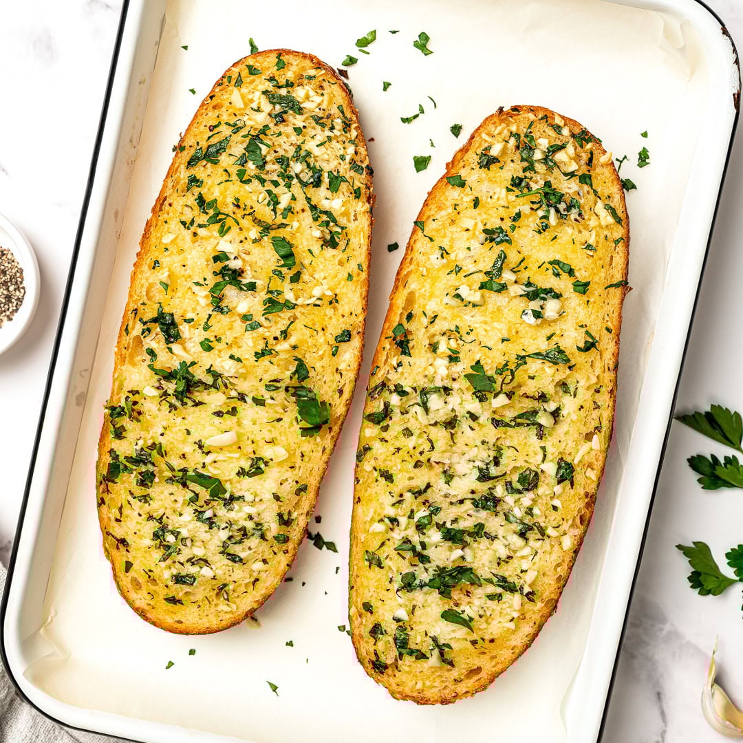 Two loaves of vegan garlic bread in pan.