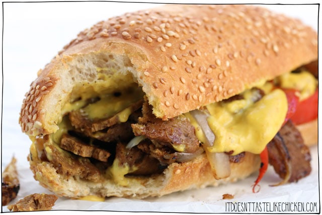 Vegan Steak Sandwich! This sandwich is packed with steak slices, sauté with onions, red bell pepper, and garlic, all topped with melty nacho cheese, and did I mention it's vegan!? #itdoesnttastelikechicken #veganrecipes #vegansandwich