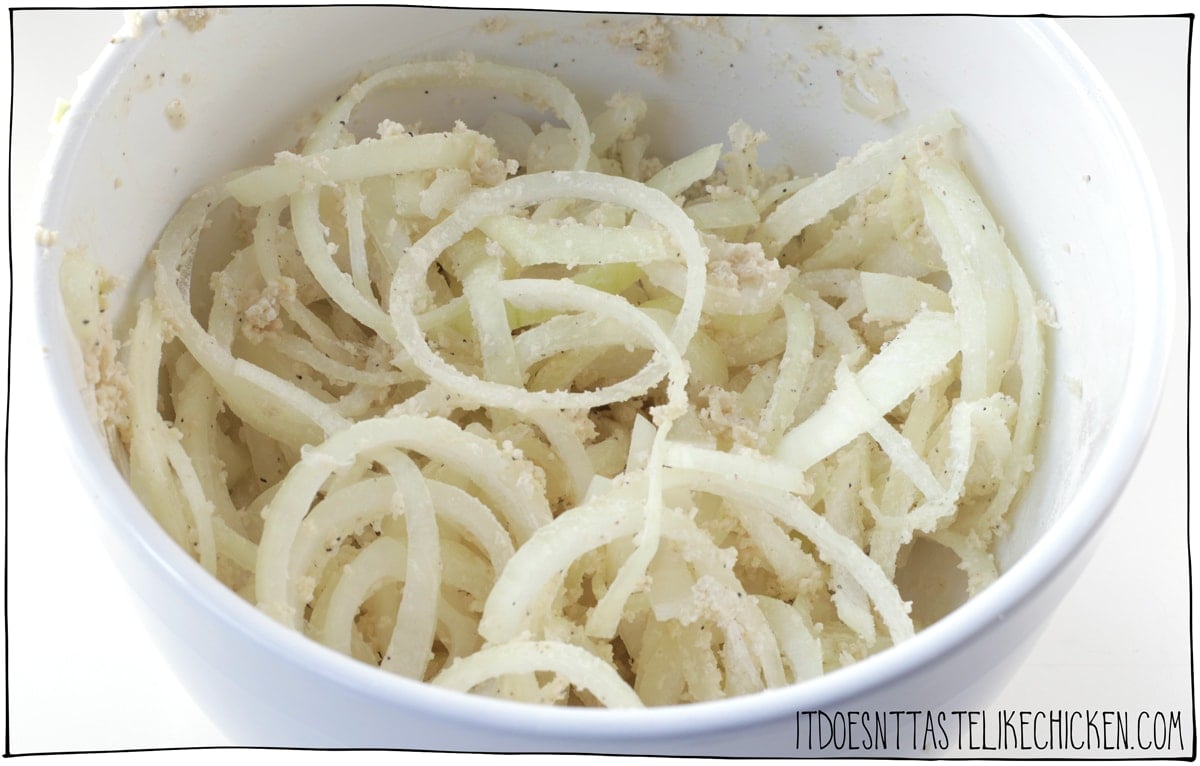 Toss the onions with plant-based milk, flour, panko, salt, and pepper.