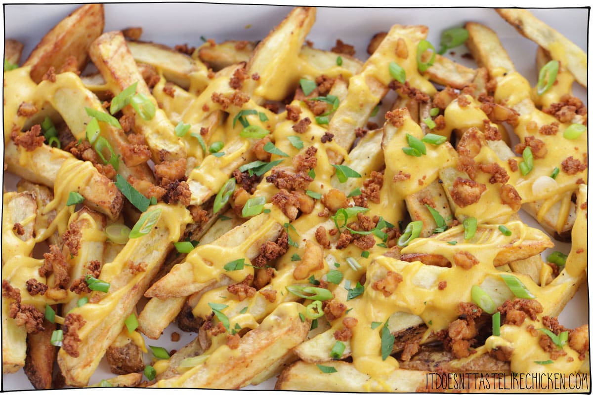 Easy Vegan Cheese Fries! Crispy french fries with homemade stretchy melty vegan nacho cheese, and tofu bacon bits. The perfect comfort food for movie night or game night. Surprisingly healthy and can even be made oil-free! #itdoesnttastelikechicken #veganrecipes #vegan