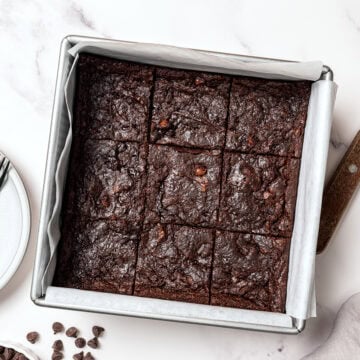 Sliced vegan brownies in parchment lined pan.