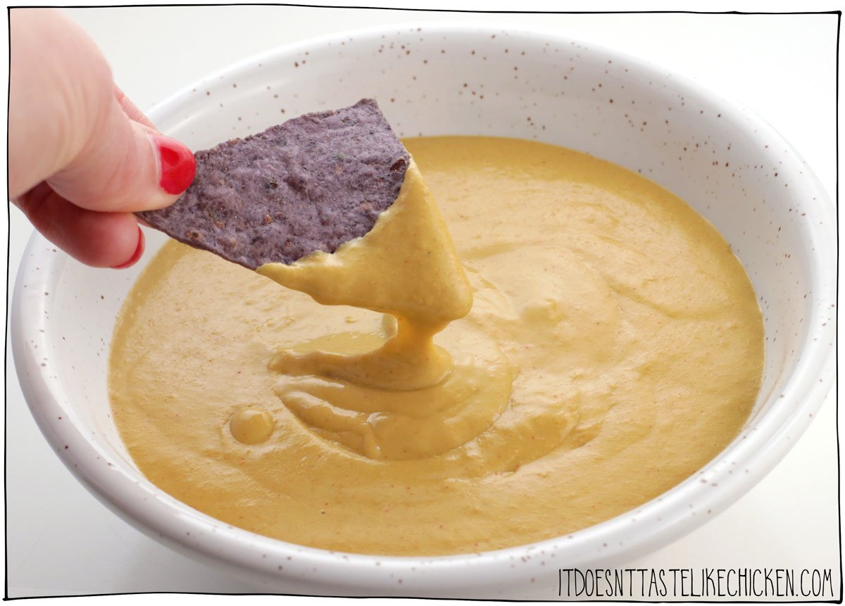 This easy vegan cheese sauce (no nuts) is the perfect vegan cheese recipe to drizzle on broccoli or a baked potato, to make nachos with, to use as a dip, to smother French fries for loaded cheesy fries (yes please!), or to enjoy with anything you like! This vegan cheese recipe is made with just 10 ingredients including raw sunflower seeds and a few other pantry staples, and when combined, they make the perfect creamy cheesy nut-free cheesy deliciousness. #itdoesnttastelikechicken #vegancheese