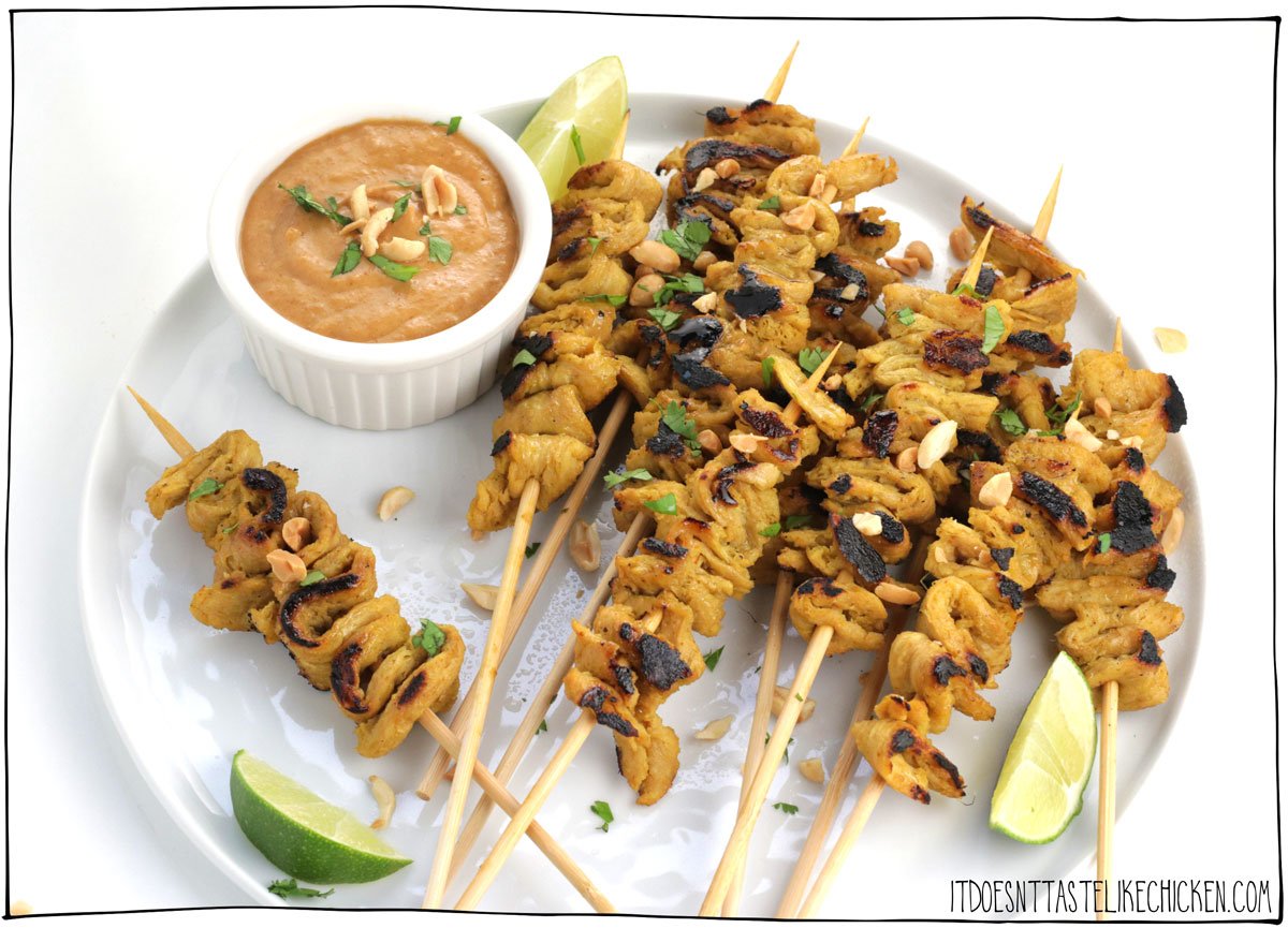 These vegan satay skewers are marinated in creamy coconut curry sauce, then grilled to perfection and served with spicy peanut sauce, and garnished with limes and chopped peanuts! Hello, deliciousness! These skewers are a super impressive appetizer or can be enjoyed as a main served with rice and veggies. #itdoesntastelikechicken #veganrecipes #soycurls