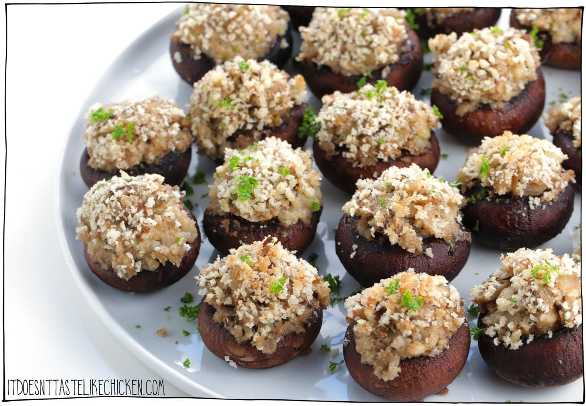 Easy Vegan Stuffed Mushrooms are the perfect party appetizer or they make a great side dish too! They look fancy but are easy to make. Mushroom caps are stuffed with vegan cream cheese, sautéd onion, garlic, panko, and seasonings, then they are topped with more panko that bakes to a crispy golden topping. These savory, bite-sized, snacks are pop-ably delicious! #itdoesnttastelikechicken #veganappetizer #appetizer