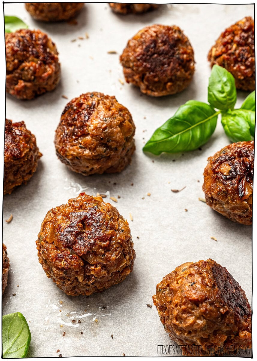 Vegan meatballs on sheet pan with fresh basil.