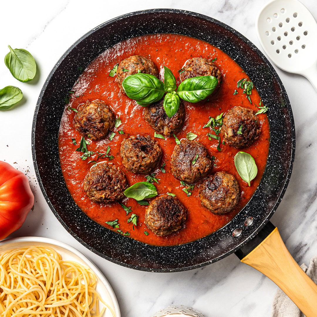 Vegan meatballs in skillet of marinara.