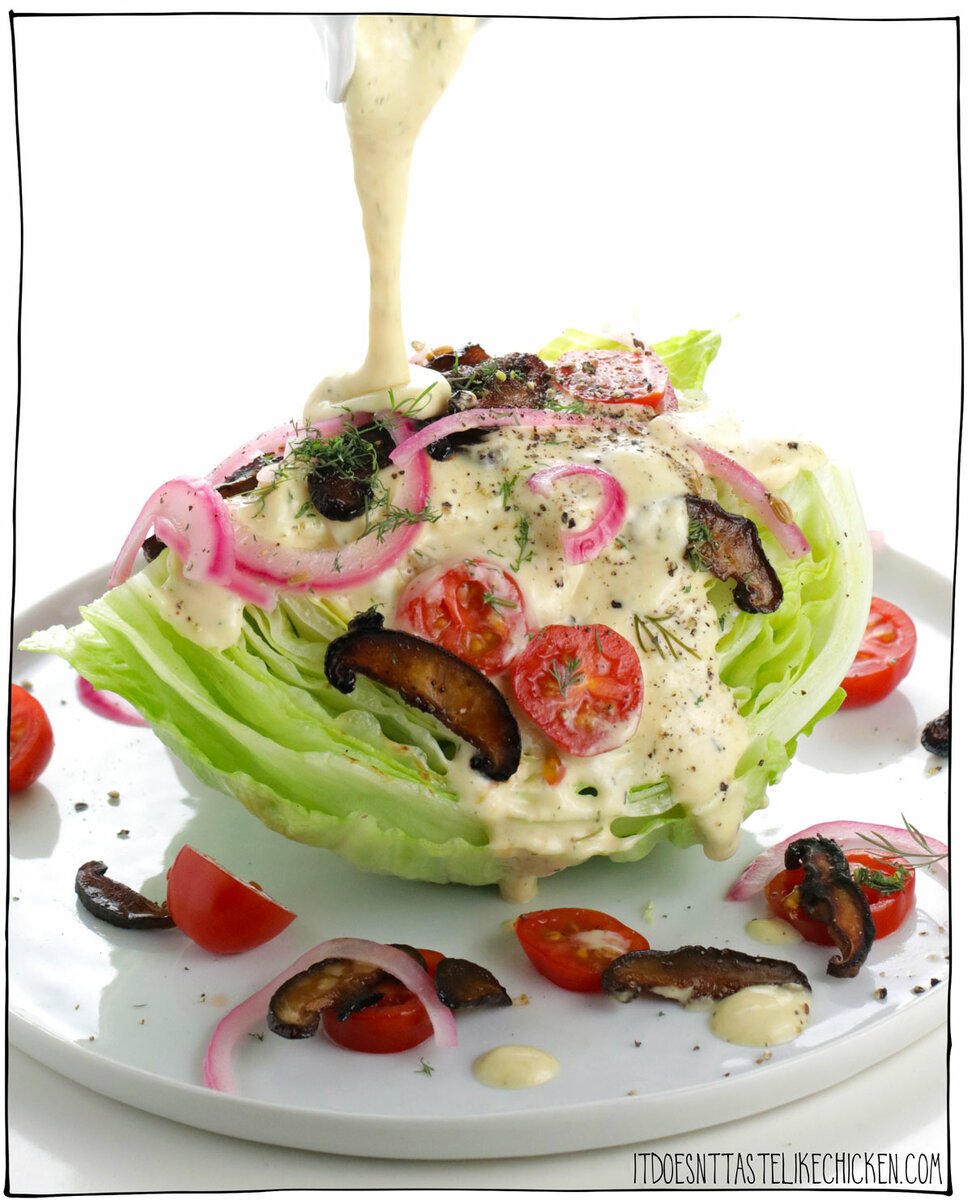 This Vegan Wedge Salad recipe is topped with vegan bacon bits, cherry tomatoes, pickled red onions, and an unbelievably delicious homemade vegan blue cheese salad dressing! This recipe is quick and easy to make (it takes less than 15 minutes to whip up) and is perfect for a fancy-looking appetizer or side dish. #itdoesnttastelikechicken #salad #veganrecipes