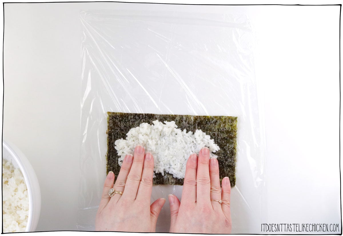 Cut a nori sheet in half then cover it in a thin layer of sushi rice