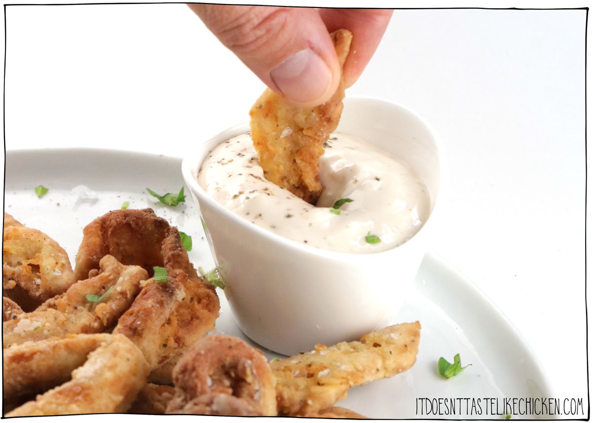 This Vegan Calamari recipe is delicious and fairly easy to make too! Instead of squid, I used marinated soy curls that are dredged in a flour coating and pan-fried until they are crispy, chewy, and delicious! Serve with lemon wedges and the garlic mayo sauce for the best fancy appetizer! #itdoesnttastelikechicken #vegan #veganseafood #veganappetizer