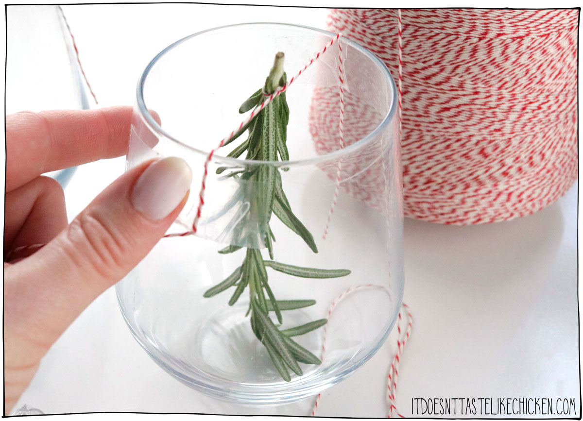 To make your Christmas tree drink, secure a sprig of rosemary upside down in the middle of a glass using a string and some tape.
