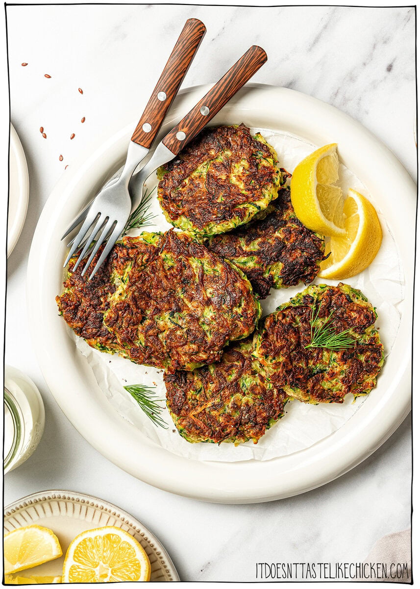 Plate of vegan zucchini fritters with two forks.