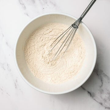 Whisking dry ingredients in mixing bowl.