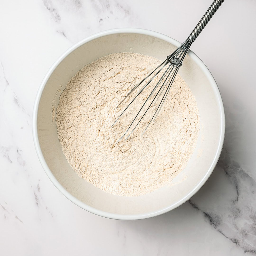 Whisking dry ingredients in mixing bowl.