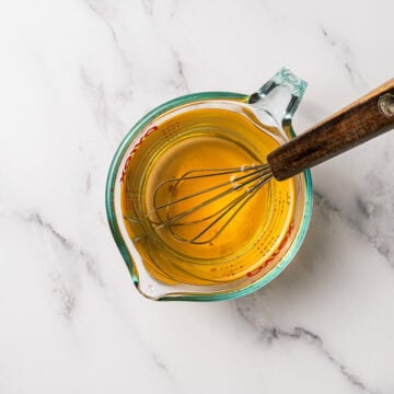 Whisking wet ingredients in liquid measuring cup.