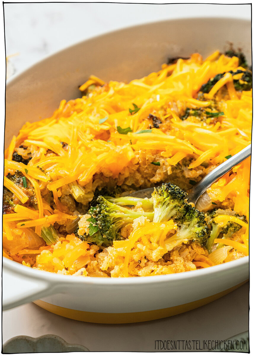 This easy Vegan Broccoli Rice Casserole is a crowd-pleaser with creamy cheese sauce, broccoli and fluffy rice. Works as a main dish or side! Spoon digging into cheesy vegan broccoli rice casserole.