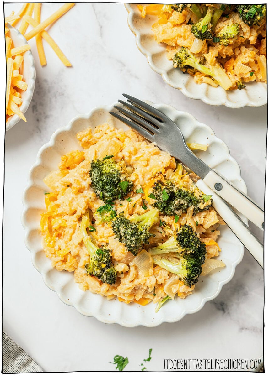 This easy Vegan Broccoli Rice Casserole is a crowd-pleaser with creamy cheese sauce, broccoli and fluffy rice. Works as a main dish or side! Plate of cheesy vegan broccoli rice casserole with fork.