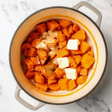 Sweet potatoes in pot with vegan butter, maple syrup, tahini, and seasonings.