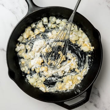 Vegan roux in skillet with whisk.