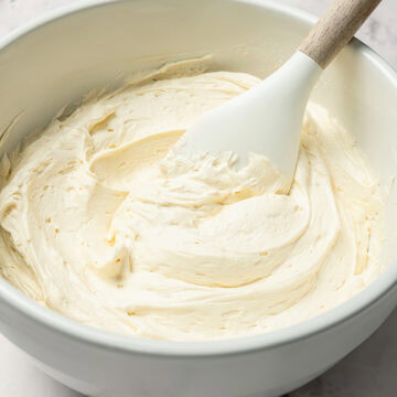 Stirring bowl of vegan buttercream frosting.