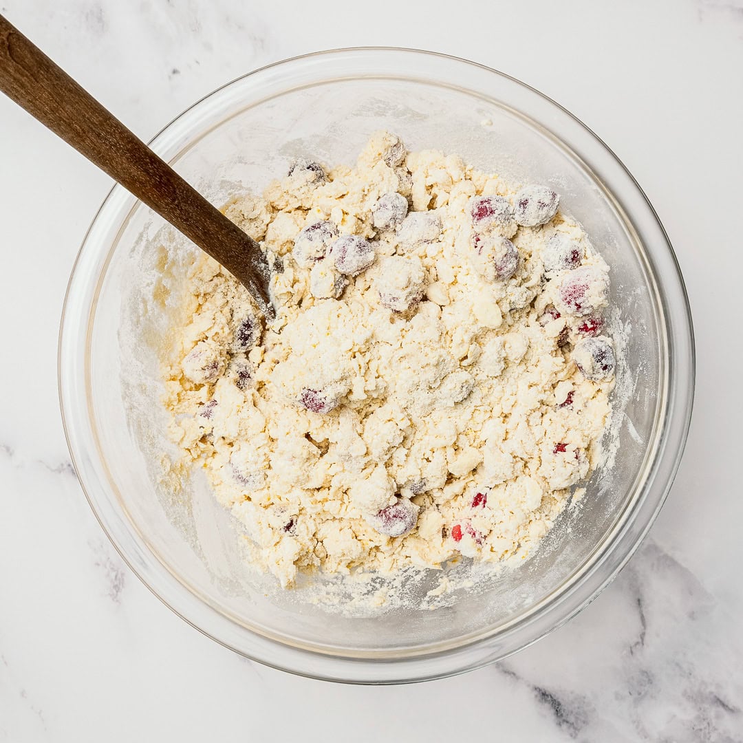 These easy Vegan Cranberry Orange Scones are flaky, citrusy, and full of festive flavor. Perfect for holiday brunches or a cozy winter treat! Stirring dough for cranberry orange scones.
