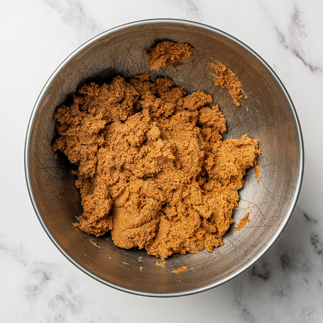 Soft, chewy and perfectly spiced, these vegan gingerbread cookies are made with rich molasses and warm spices. Easy to roll, cut and decorate! Vegan gingerbread cookie dough in mixing bowl.