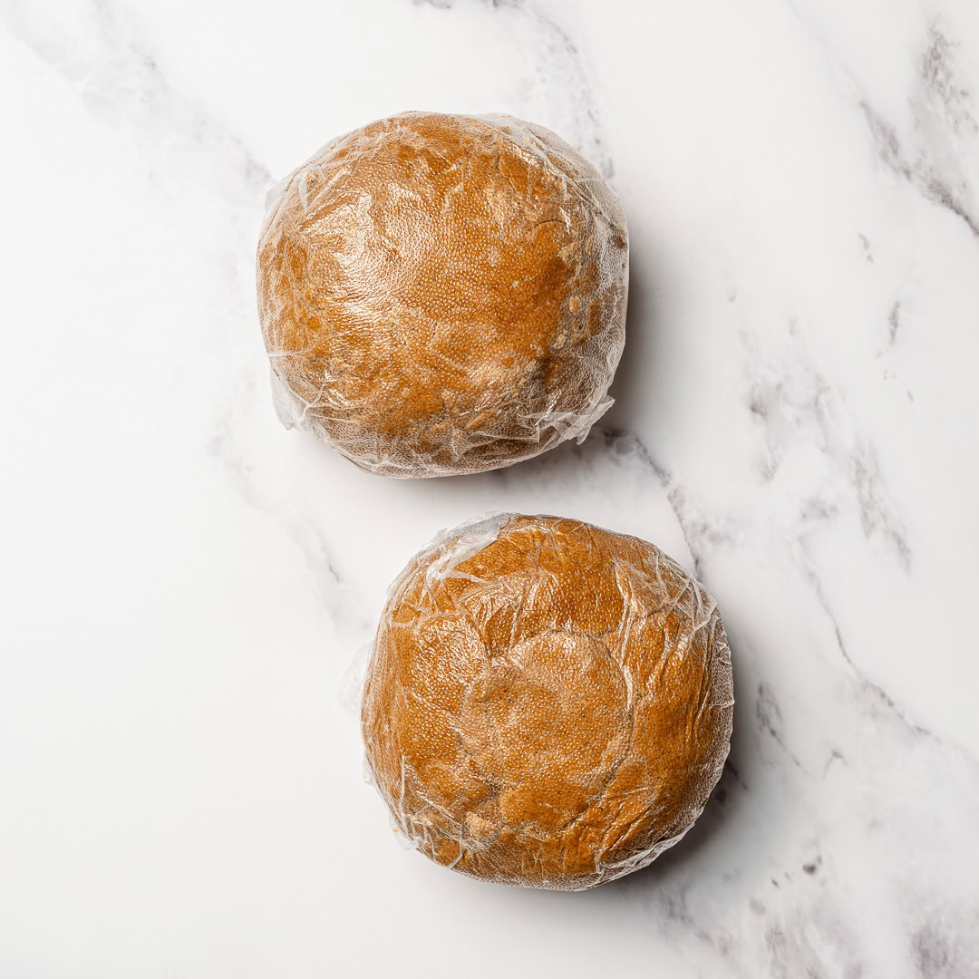 Soft, chewy and perfectly spiced, these vegan gingerbread cookies are made with rich molasses and warm spices. Easy to roll, cut and decorate! 2 balls of vegan gingerbread cookie dough wrapped in plastic