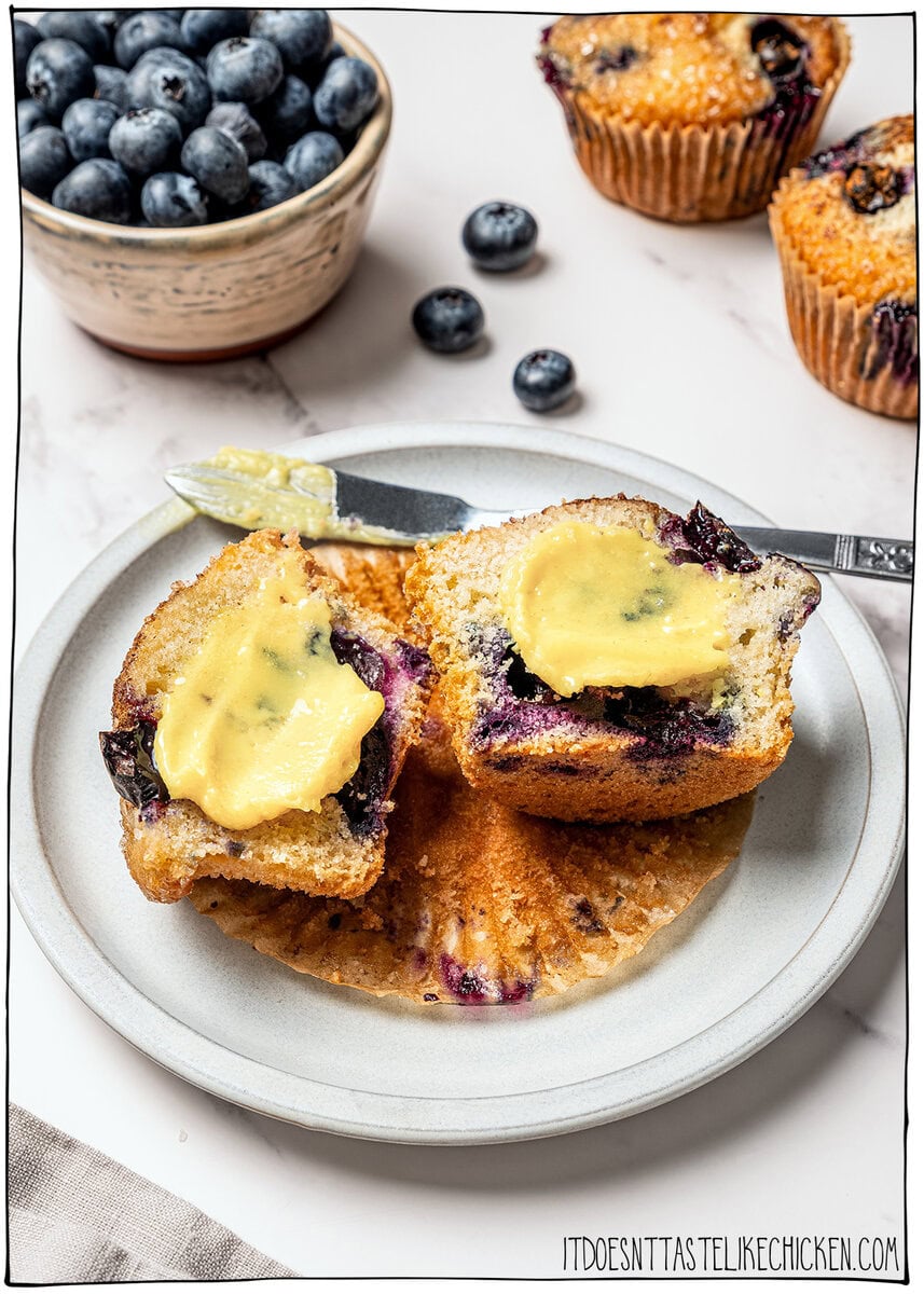 This homemade vegan butter melts, spreads and tastes like the real thing! Easy to make with everyday ingredients, you can even bake with it. Blueberry muffin cut in half and topped with vegan butter.