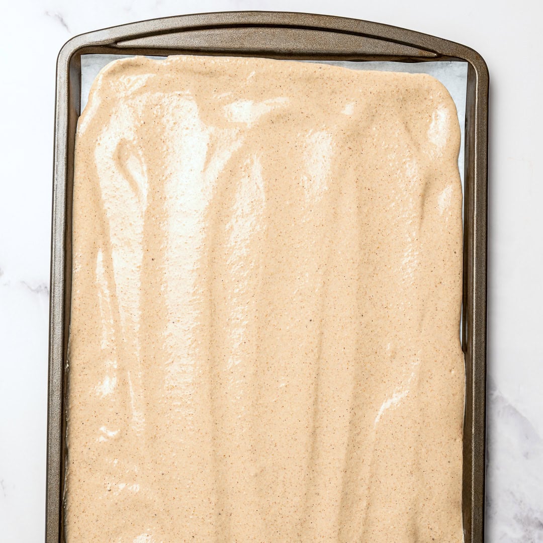 These fluffy vegan protein pancakes are mixed in the blender for an easy healthy breakfast with skillet or sheet-pan options. Gluten-free too! Vegan protein pancake batter spread on sheet pan.