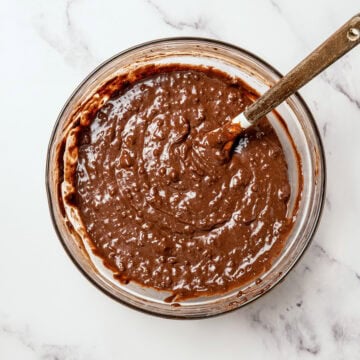 Vegan chocolate cupcake batter in bowl with rubber spatula.