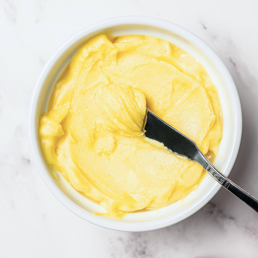 This homemade vegan butter melts, spreads and tastes like the real thing! Easy to make with everyday ingredients, you can even bake with it. Vegan butter in bowl with butterknife.