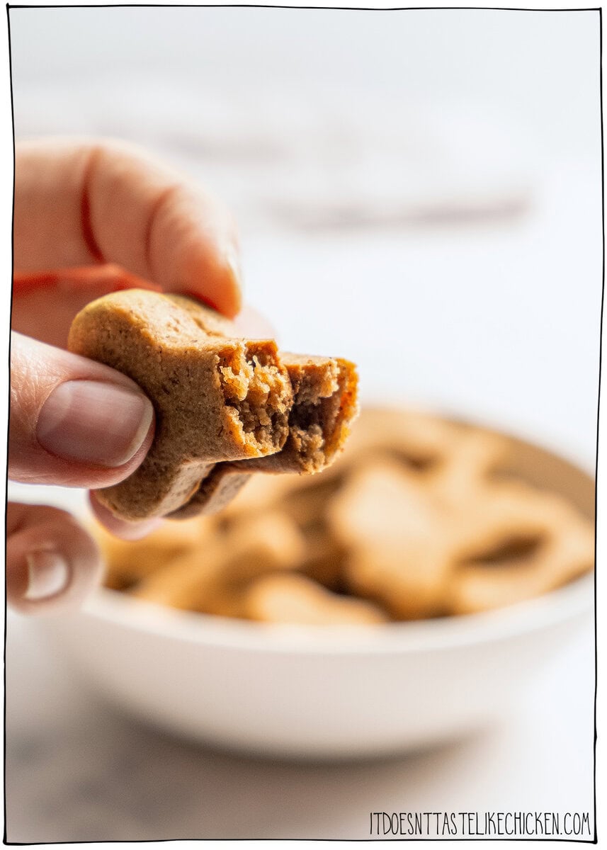 These quick and easy homemade soft dog treats use just 5 simple ingredients and bake up chewy, peanut buttery, and pup-approved! Hand holding homemade soft dog treat that is broken in half to show soft texture.