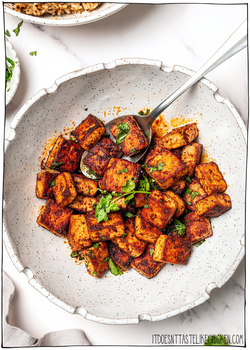 Overhead shot of marinated tofu cubes in a bowl with cilantro.